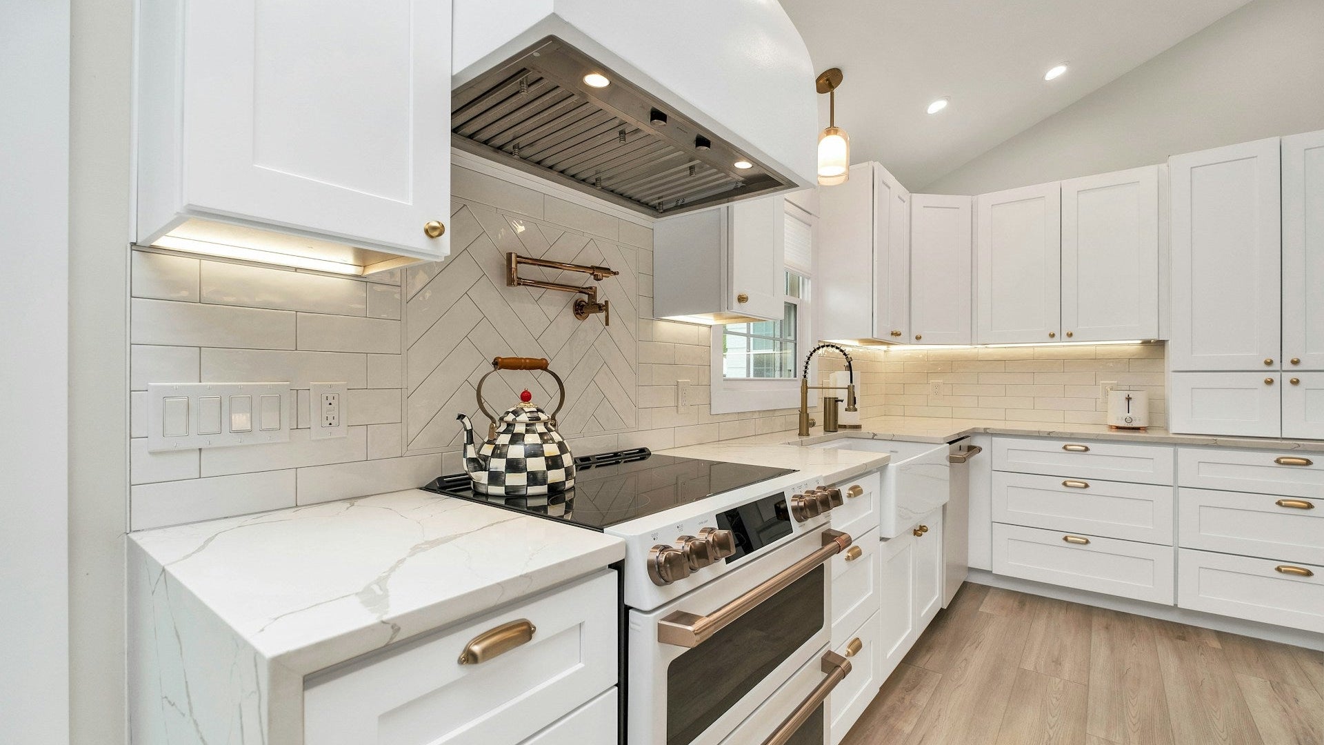 Interior Remodeling - Modern kitchen with white cabinets, marble countertops, and stainless steel appliances.